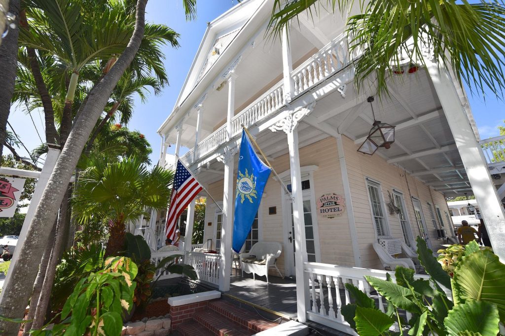 Historic white house with flags and lush tropical plants